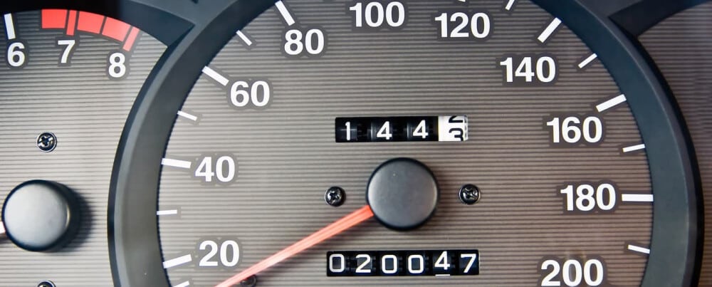 Close-up of a car speedometer displaying 144 km/h and an odometer reading 20047 kilometers.