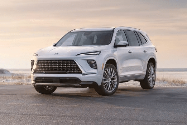 White SUV parked on a beachside road under a cloudy sky, highlighting its modern design.