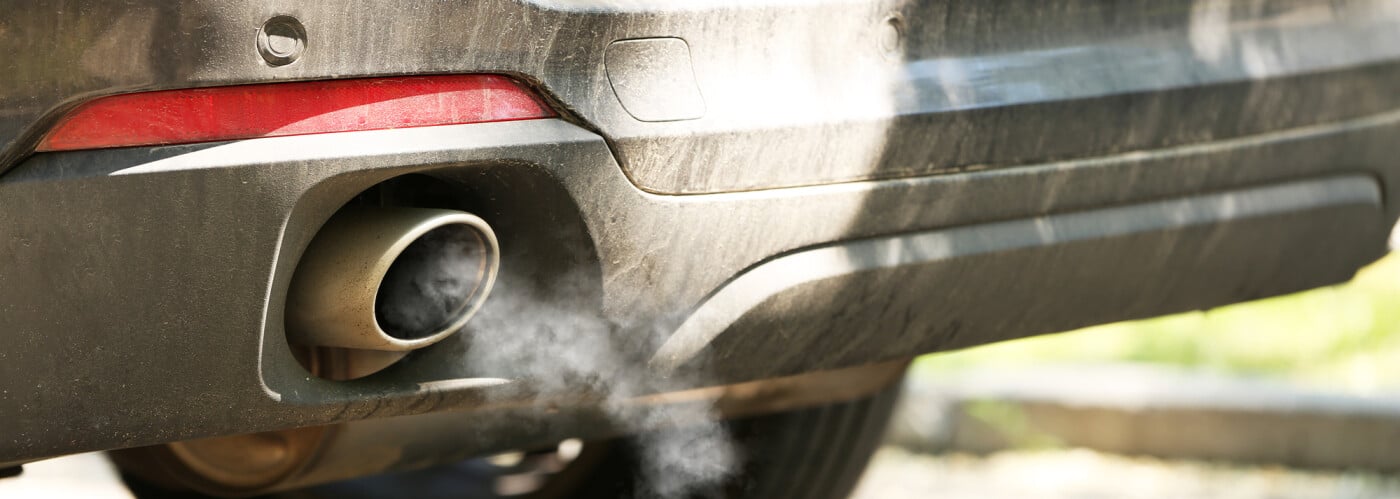 Car exhaust emitting smoke, highlighting vehicle emissions and pollution issues.