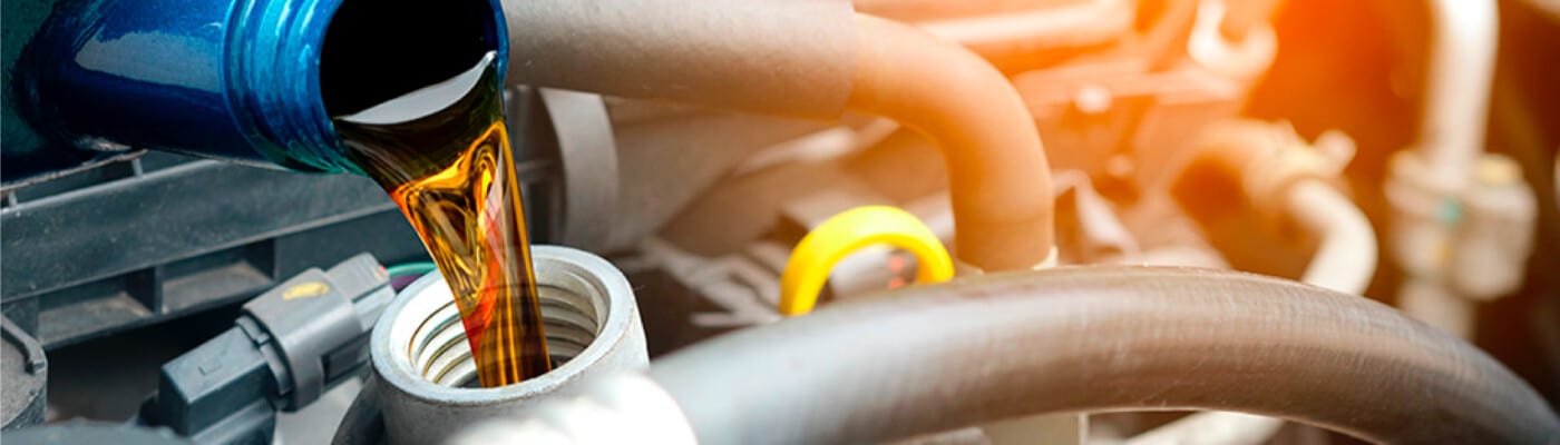Engine oil being poured into a car engine, showcasing vehicle maintenance.